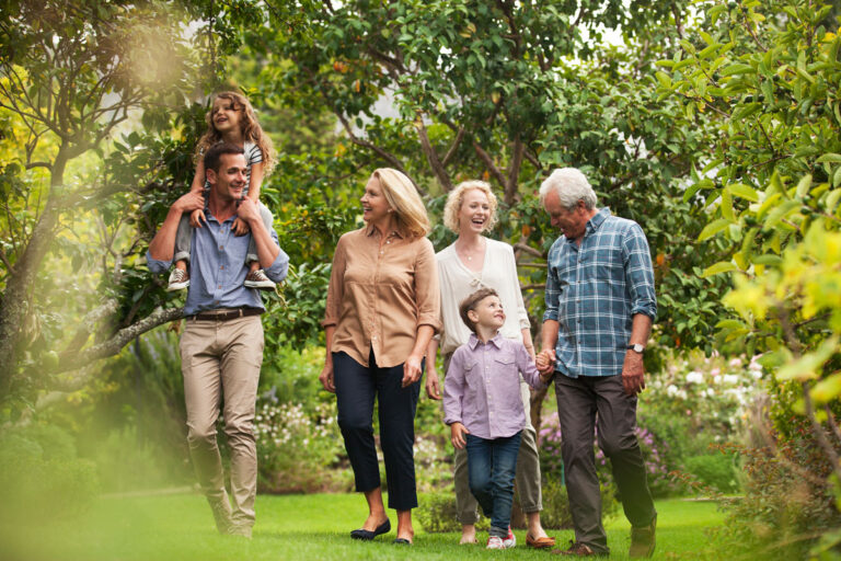 A family strolls together through a vibrant garden, enjoying nature and each other's company.